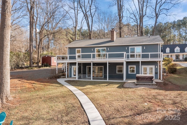 rear view of property with a yard and a deck