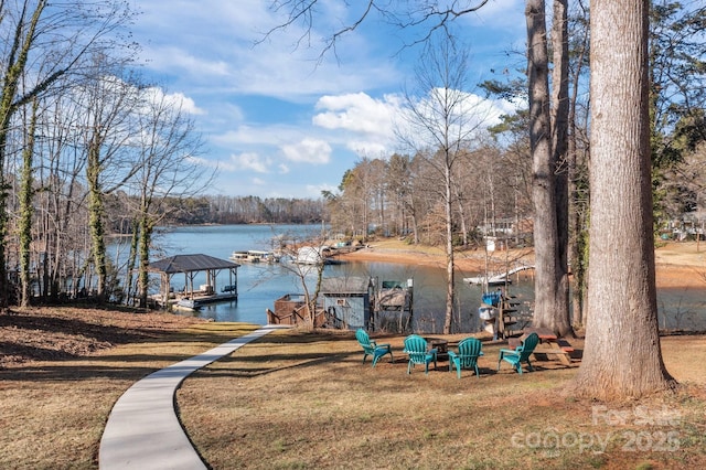 view of dock with a water view and a lawn