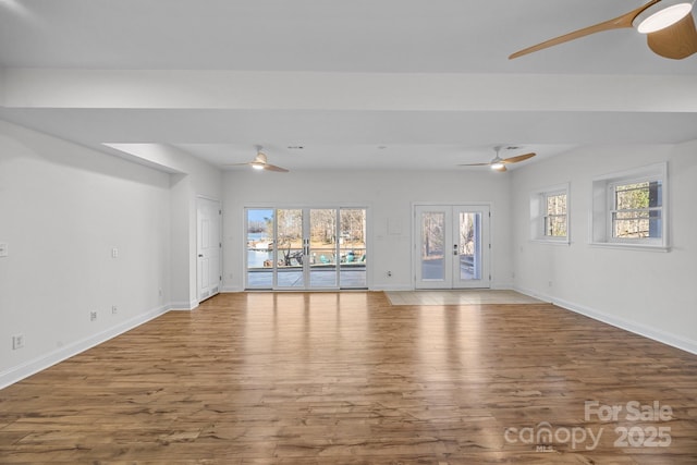 unfurnished living room with french doors, ceiling fan, and wood-type flooring