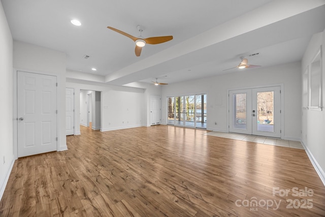 unfurnished living room featuring ceiling fan, light hardwood / wood-style floors, and french doors