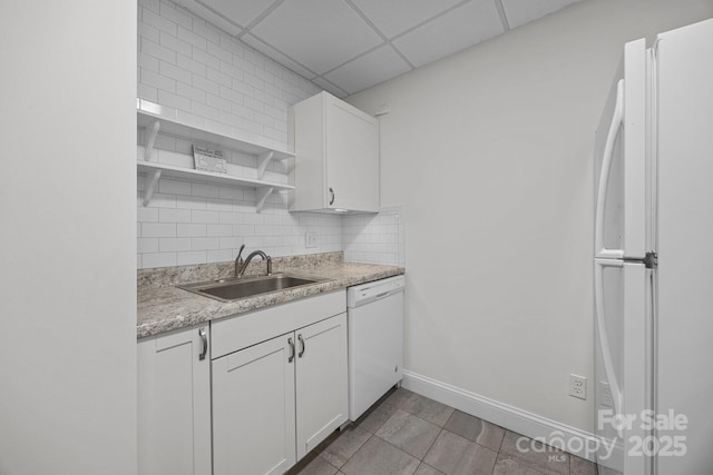 kitchen with sink, white cabinets, white appliances, decorative backsplash, and a drop ceiling