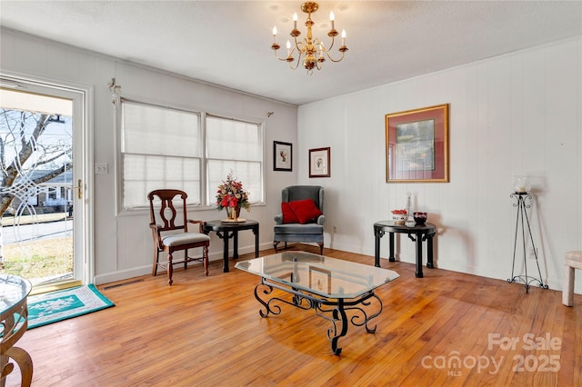 sitting room with a notable chandelier and light wood-type flooring