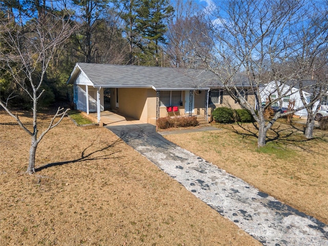 ranch-style home featuring a carport, a porch, and a front yard