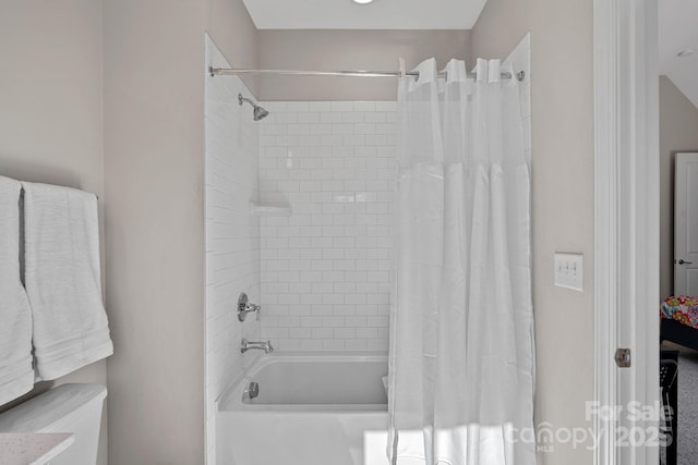 bathroom with shower / tub combo and toilet