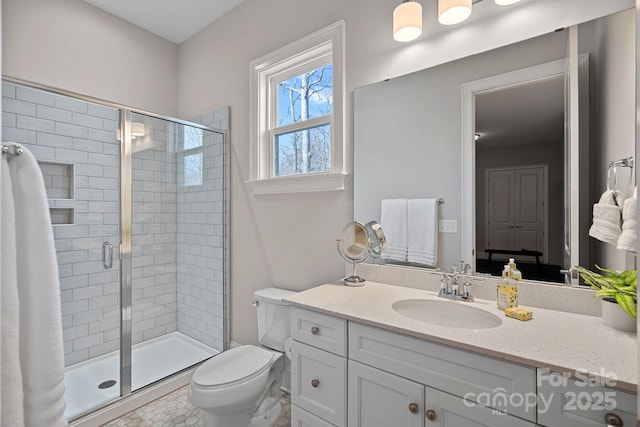 bathroom with vanity, a shower with shower door, and toilet