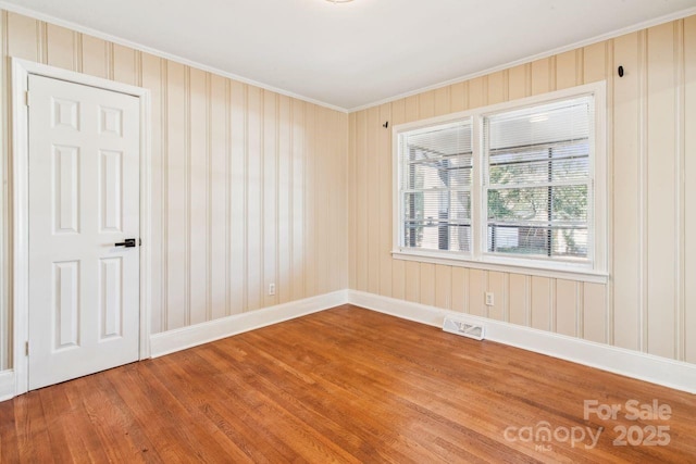 empty room featuring crown molding and hardwood / wood-style floors