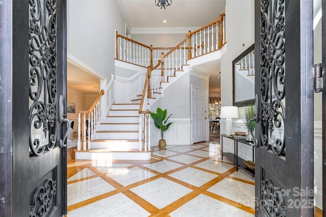 foyer entrance with ornamental molding and a high ceiling