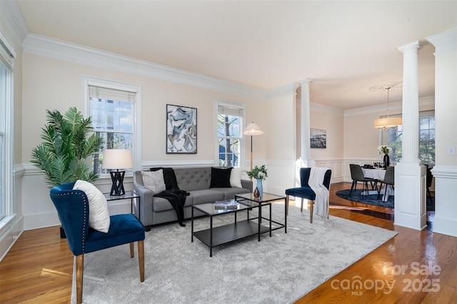 living room featuring a healthy amount of sunlight and ornate columns