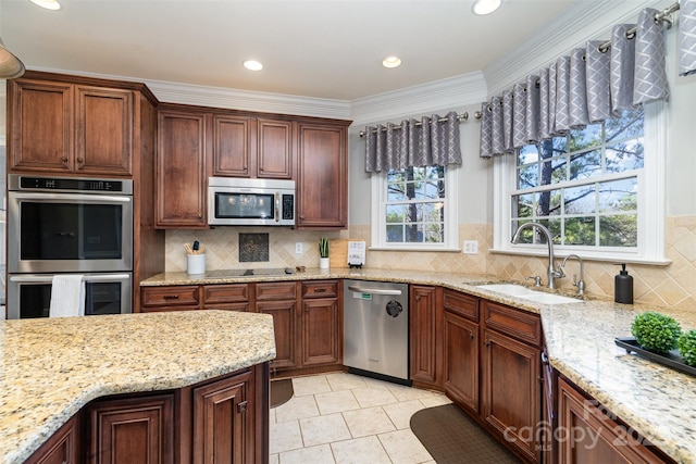 kitchen featuring stainless steel appliances, light stone countertops, sink, and decorative backsplash