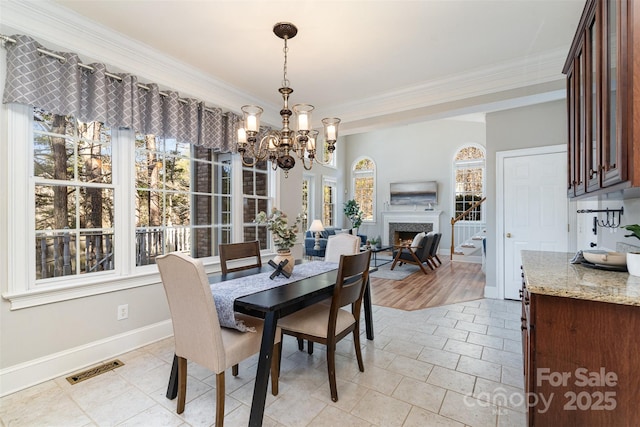 tiled dining area featuring ornamental molding and a notable chandelier