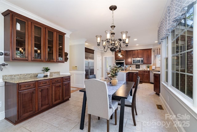 dining room featuring sink, crown molding, and a chandelier