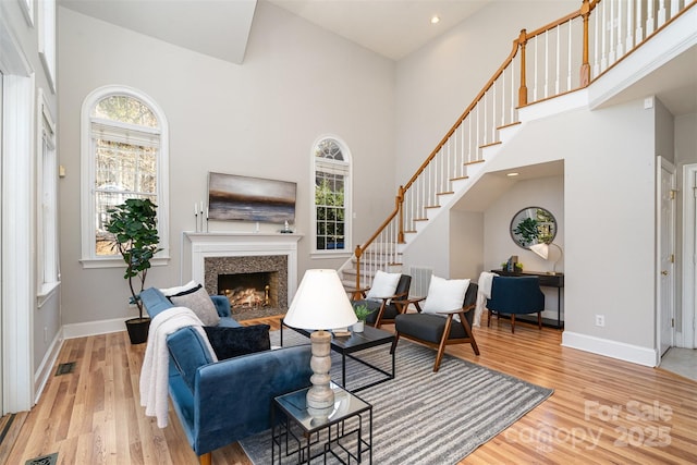 living room with a towering ceiling and light hardwood / wood-style flooring