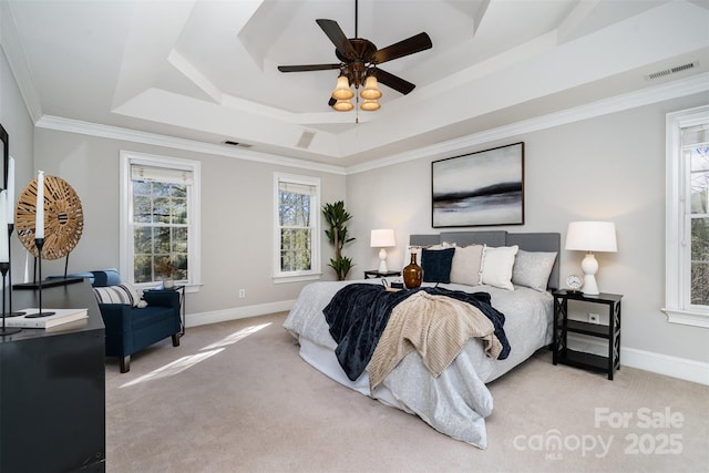 carpeted bedroom with crown molding, ceiling fan, and a tray ceiling