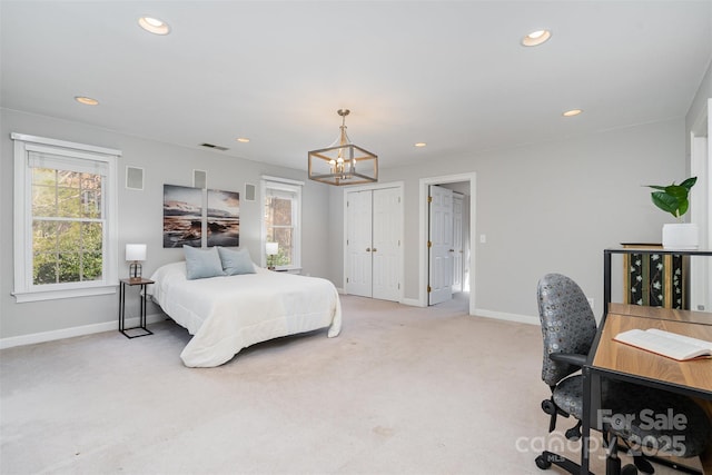 carpeted bedroom with an inviting chandelier