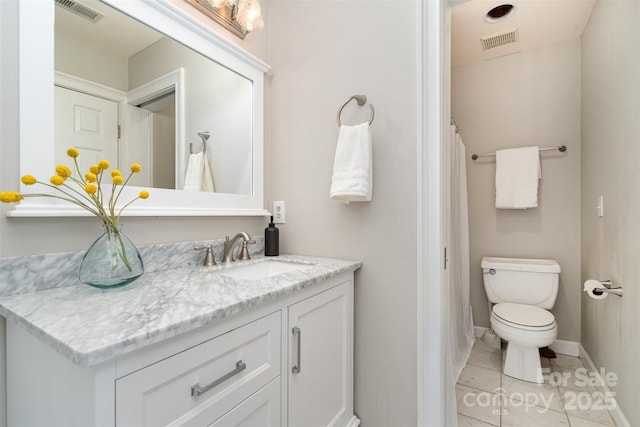 bathroom featuring vanity, toilet, and tile patterned flooring