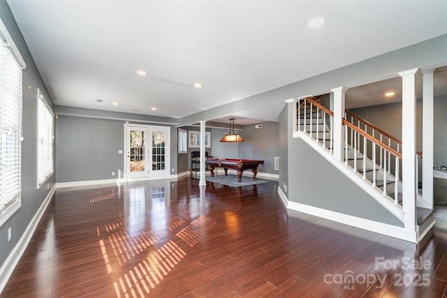 unfurnished living room featuring billiards, dark hardwood / wood-style flooring, and ornate columns