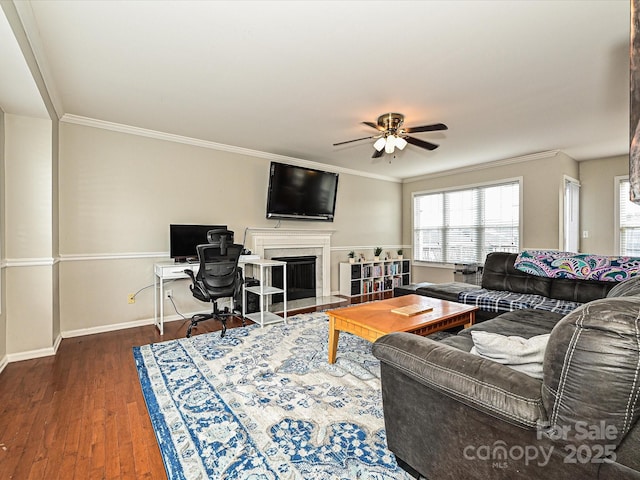 living room featuring crown molding, a high end fireplace, ceiling fan, and dark hardwood / wood-style flooring