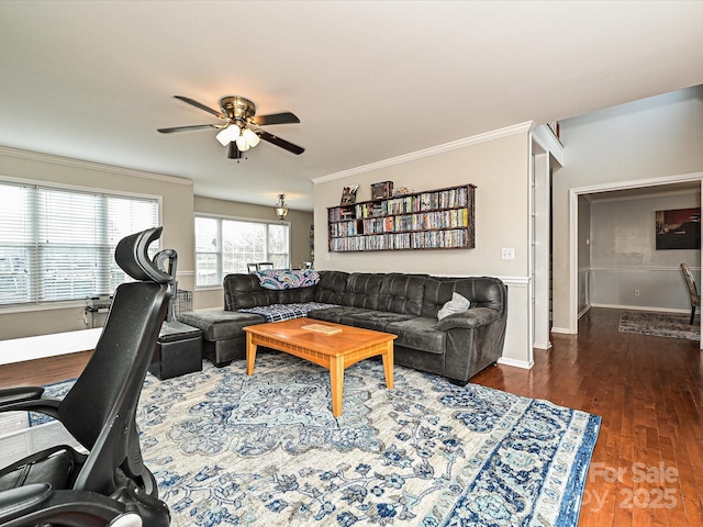 living room with dark wood-type flooring, ornamental molding, and ceiling fan