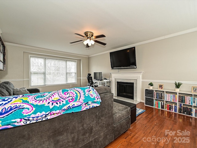 bedroom featuring ceiling fan, ornamental molding, a high end fireplace, and dark hardwood / wood-style floors