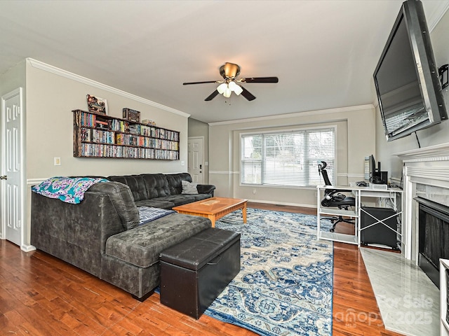 living room featuring hardwood / wood-style floors, a high end fireplace, ornamental molding, and ceiling fan