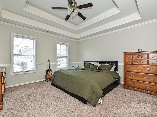 carpeted bedroom featuring a tray ceiling, ornamental molding, and ceiling fan