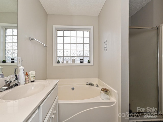 bathroom with vanity, separate shower and tub, and a textured ceiling