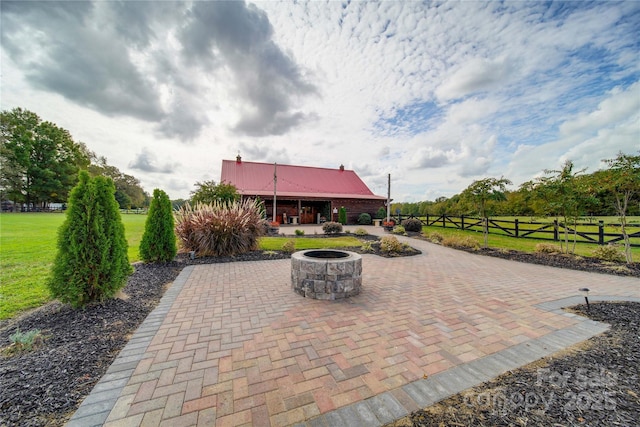 view of community featuring a yard, a patio area, and a fire pit