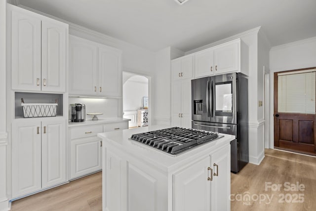 kitchen featuring appliances with stainless steel finishes, a center island, light hardwood / wood-style floors, and white cabinets