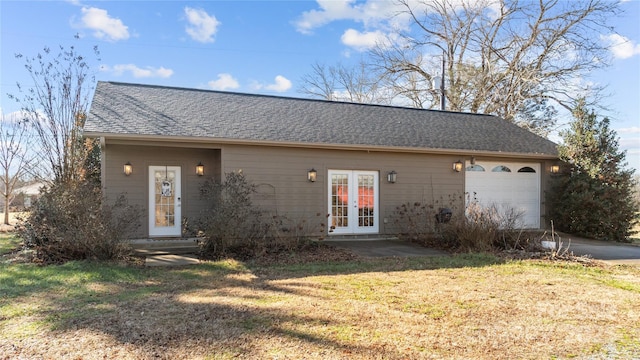 ranch-style home with a garage, a front lawn, and french doors