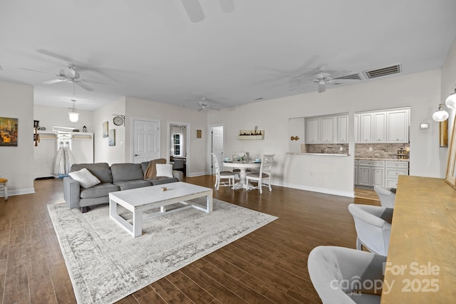 living room featuring ceiling fan and dark hardwood / wood-style floors