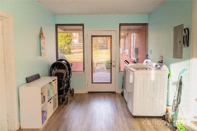 laundry room featuring crown molding, laundry area, light wood-style floors, washing machine and dryer, and electric panel