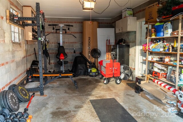 garage with a garage door opener and concrete block wall