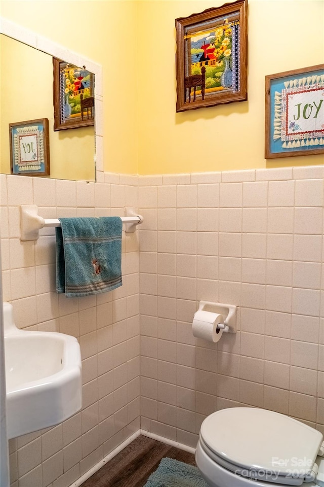 bathroom with tile walls, a wainscoted wall, toilet, and wood finished floors
