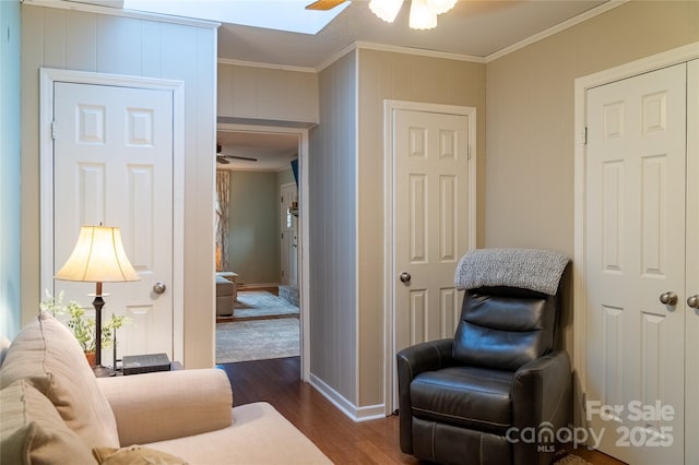 sitting room featuring crown molding, dark wood finished floors, ceiling fan, and baseboards