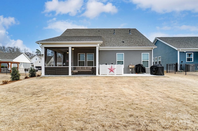 back of property featuring a patio, a yard, and a sunroom