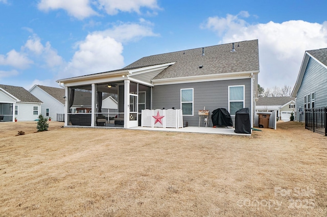 rear view of property featuring a patio, a sunroom, and a yard