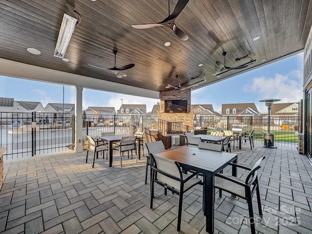 view of patio with a fireplace and ceiling fan