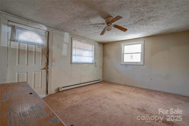 carpeted spare room featuring ceiling fan, a textured ceiling, and baseboard heating