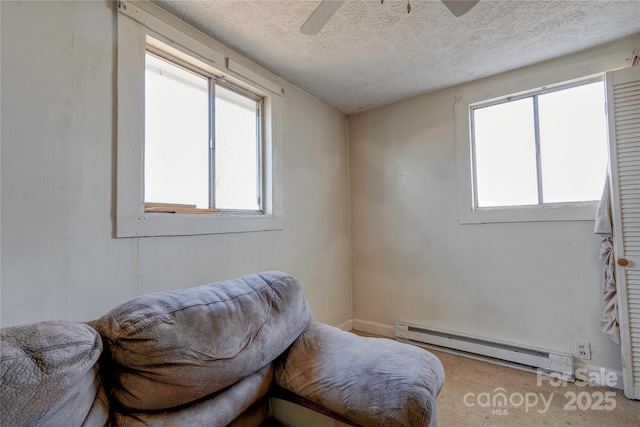 sitting room with baseboard heating, ceiling fan, and a textured ceiling