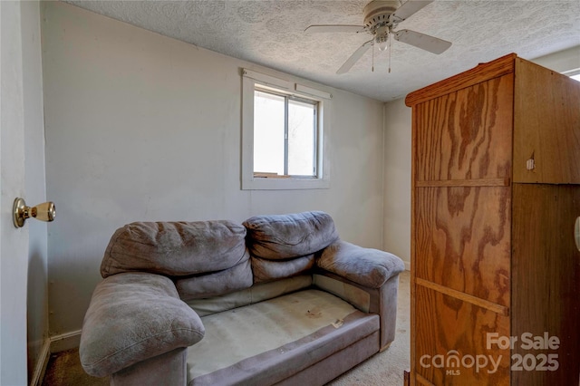 living room featuring ceiling fan and a textured ceiling