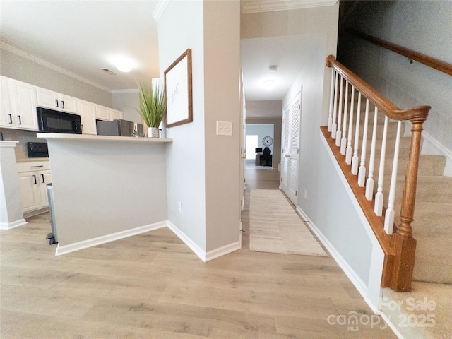 interior space with crown molding and light hardwood / wood-style flooring