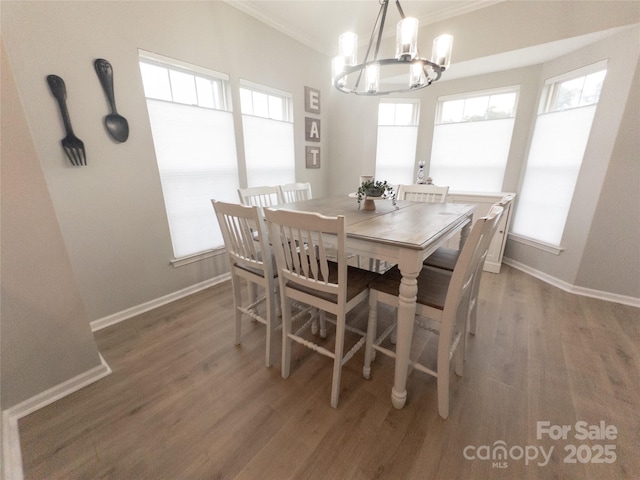 dining area featuring ornamental molding, dark hardwood / wood-style floors, and an inviting chandelier