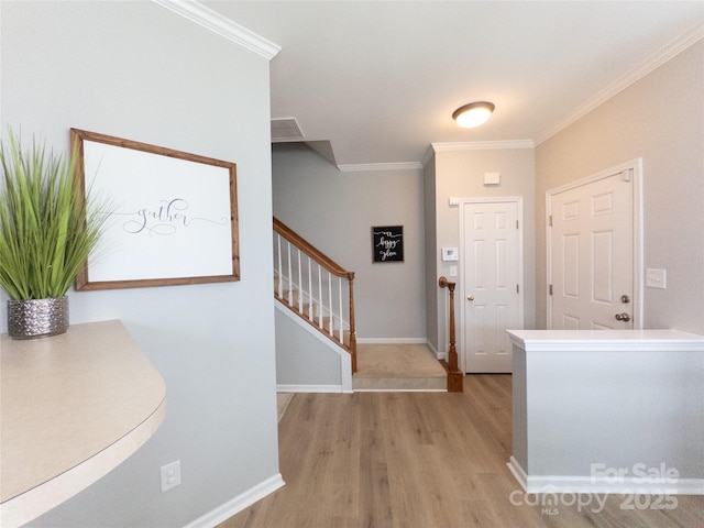 entryway featuring crown molding and light hardwood / wood-style flooring