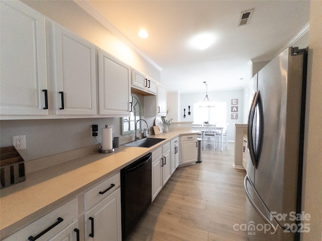 kitchen featuring sink, stainless steel refrigerator, black dishwasher, pendant lighting, and white cabinets