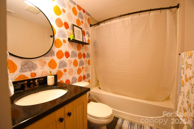 full bathroom with vanity, shower / bath combo with shower curtain, and toilet