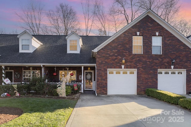 view of front of home with a garage, a lawn, and covered porch