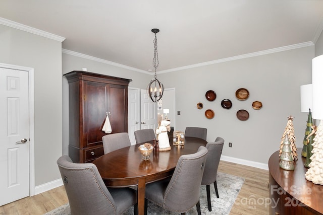 dining room with crown molding, a notable chandelier, and light hardwood / wood-style floors