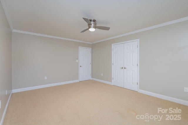 unfurnished bedroom with ceiling fan, light colored carpet, ornamental molding, and a closet