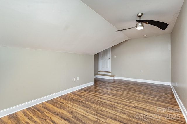 additional living space featuring hardwood / wood-style flooring, vaulted ceiling, and ceiling fan