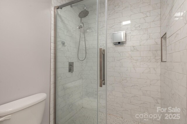 bathroom with an enclosed shower and toilet